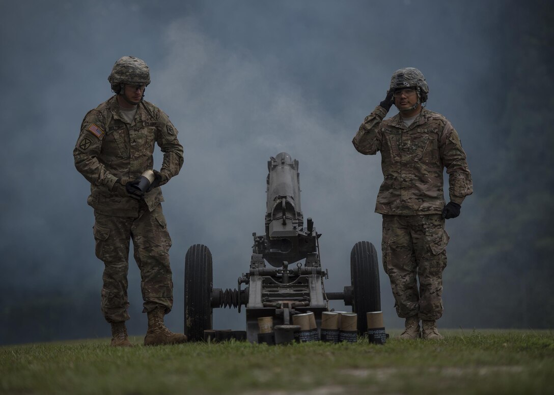 Fort Jackson Salute Battery member Staff Sgt. Elvis Servellon of Omaha, Neb. salutes after firing a Howitzer M116 during a retirement ceremony for Brig. Gen. Janice M. Haigler, deputy commanding general of the 335th Signal Command (Theater), as fellow gunner Sgt. Ryan Skelton, of Denver, Co., moves a hot casing, at Fort Jackson, S.C., July 16, 2016. (U.S. Army photo by Staff Sgt. Ken Scar)