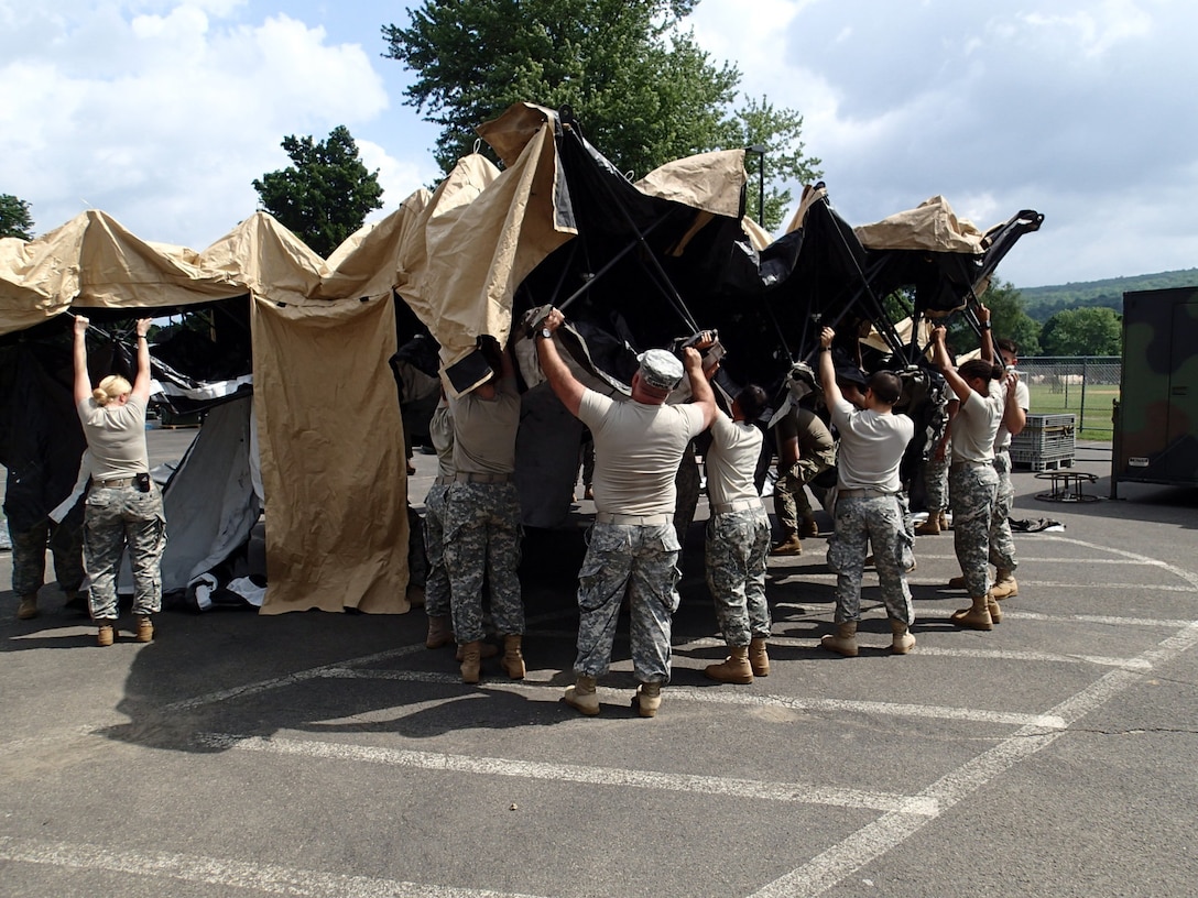 Soldiers from Company A, 48th Combat Support Hospital out of Fort Story, Va., prepare tents for veterinary services during Greater Chenango Cares July 14, 2016. Greater Chenango Cares is one of the Innovative Readiness Training missions which provides real-world training in a joint civil-military environment while delivering world-class medical care to the people of Chenango County, N.Y., from July 15-24.