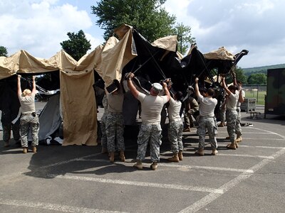 Soldiers from Company A, 48th Combat Support Hospital out of Fort Story, Va., prepare tents for veterinary services during Greater Chenango Cares July 14, 2016. Greater Chenango Cares is one of the Innovative Readiness Training missions which provides real-world training in a joint civil-military environment while delivering world-class medical care to the people of Chenango County, N.Y., from July 15-24.