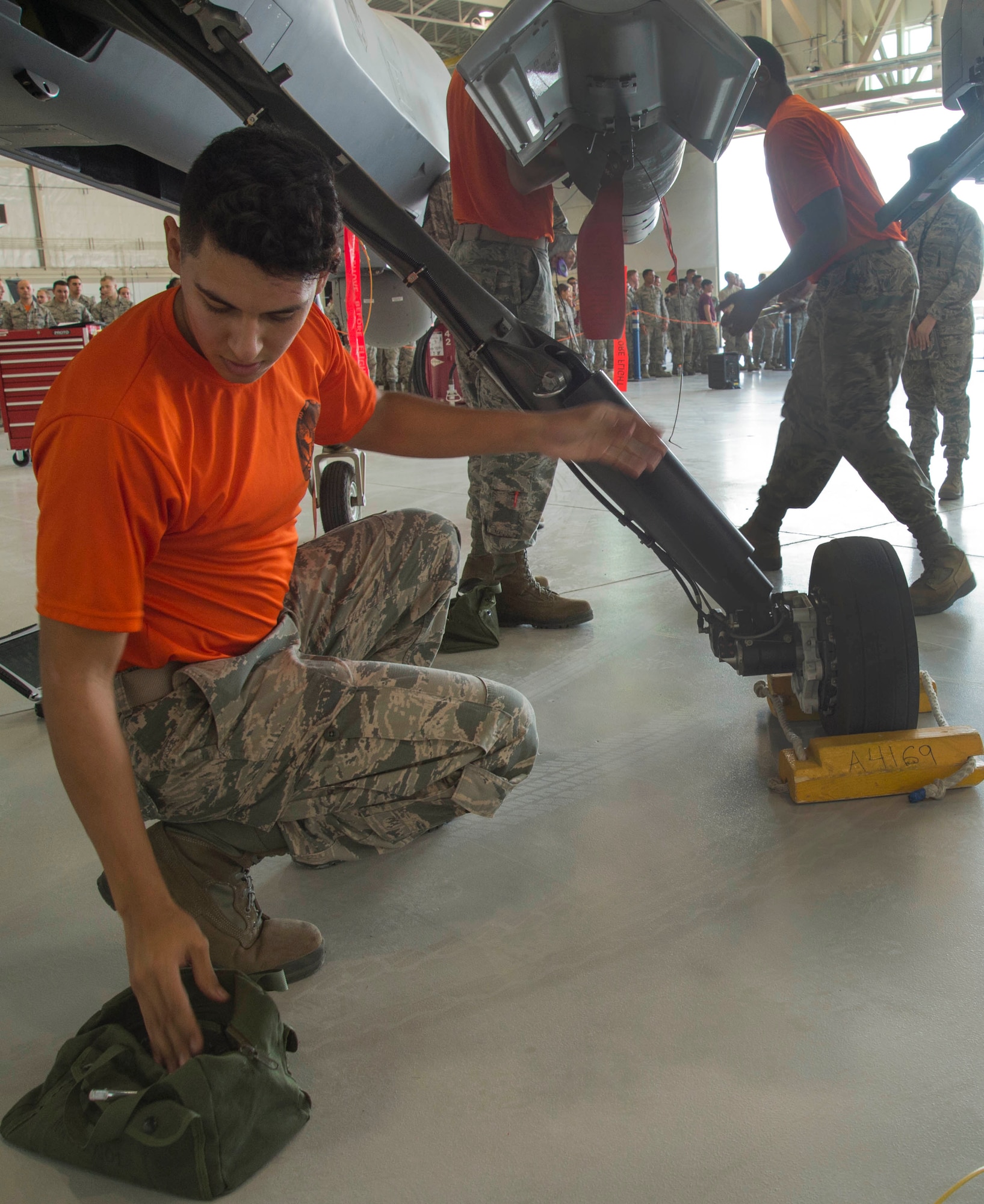 Airman 1st Class Gabriel, Tiger Aircraft Maintenance Unit load crew member, performs maintenance on an MQ-9 Reaper during the Load Crew of the Quarter competition July 1, 2016, at Creech Air Force Base, Nevada. The competition consists of two three-man crews who are responsible for loading munitions safely while under a time limit. (U.S. Air Force photo by Airman 1st Class James Thompson/Released)