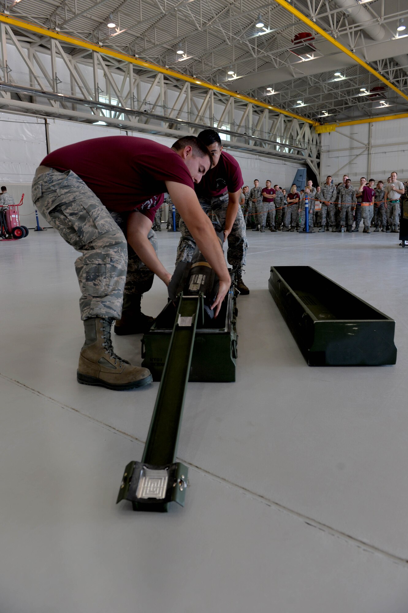 Senior Airman Dustin, 432nd Aircraft Maintenance Squadron load crew chief, and Airman 1st Class Gabriel, 432nd AMXS load crew member, perform a two man munitions movement July 1, 2016, at Creech Air Force Base, Nevada. Teams are given no knowledge of which munitions they will work with during the load, meaning that each team must visit the weapons standardization section to train and keep their skills sharpened for the competition. (U.S. Air Force photo by Airman 1st Class Kristan Campbell)