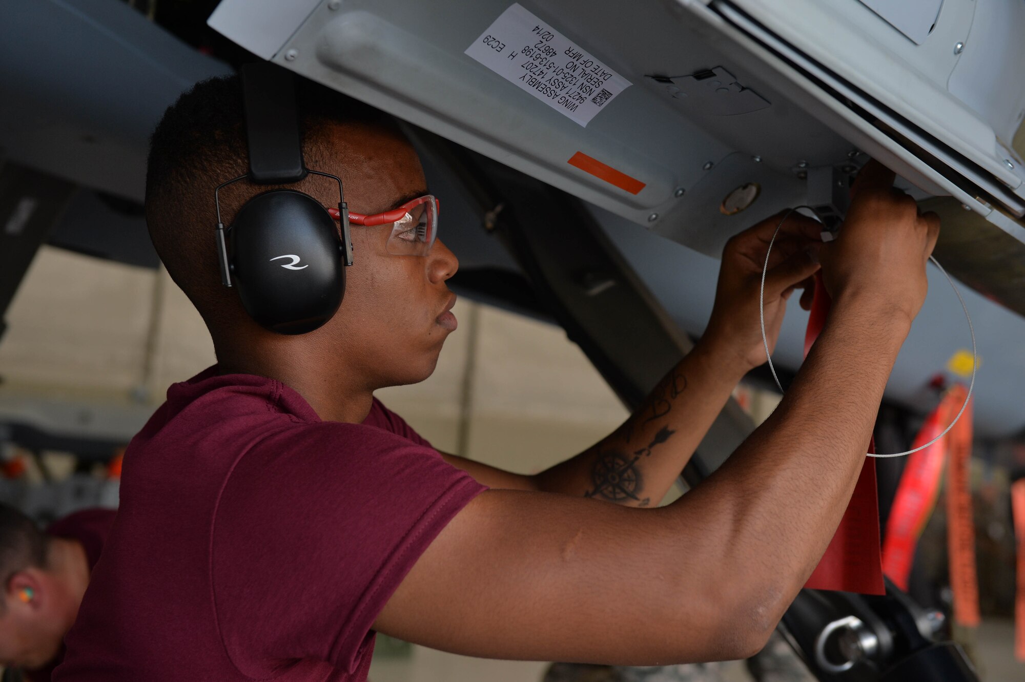 Airman 1st Class Malik, 432nd Aircraft Maintenance Squadron load crew member, attaches a safety tag on an MQ-9 Reaper July 1, 2016, at Creech Air Force Base, Nevada. The tag, which reads “remove before flight,” is a safety measure used by aircrews to ensure safety during each step of a munitions load. (U.S. Air Force photo by Airman 1st Class Kristan Campbell/Released)