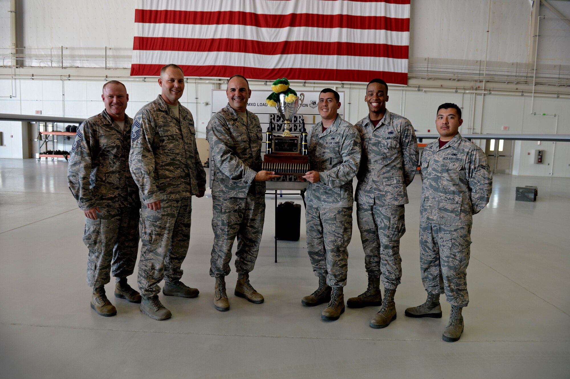 Airmen from the 432nd Aircraft Maintenance Squadron’s Reaper Aircraft Maintenance Unit pose with leadership for a photo July 1, 2016, at Creech Air Force Base, Nevada. The winners of this quarter’s Load Crew of the Quarter competition are Airman are: Senior Airman Dustin, 432nd AMXS load crew chief, Airman 1st Class Malik, 432nd AMXS load crew member, and Airman 1st Class Gabriel, 432nd AMXS load crew member.