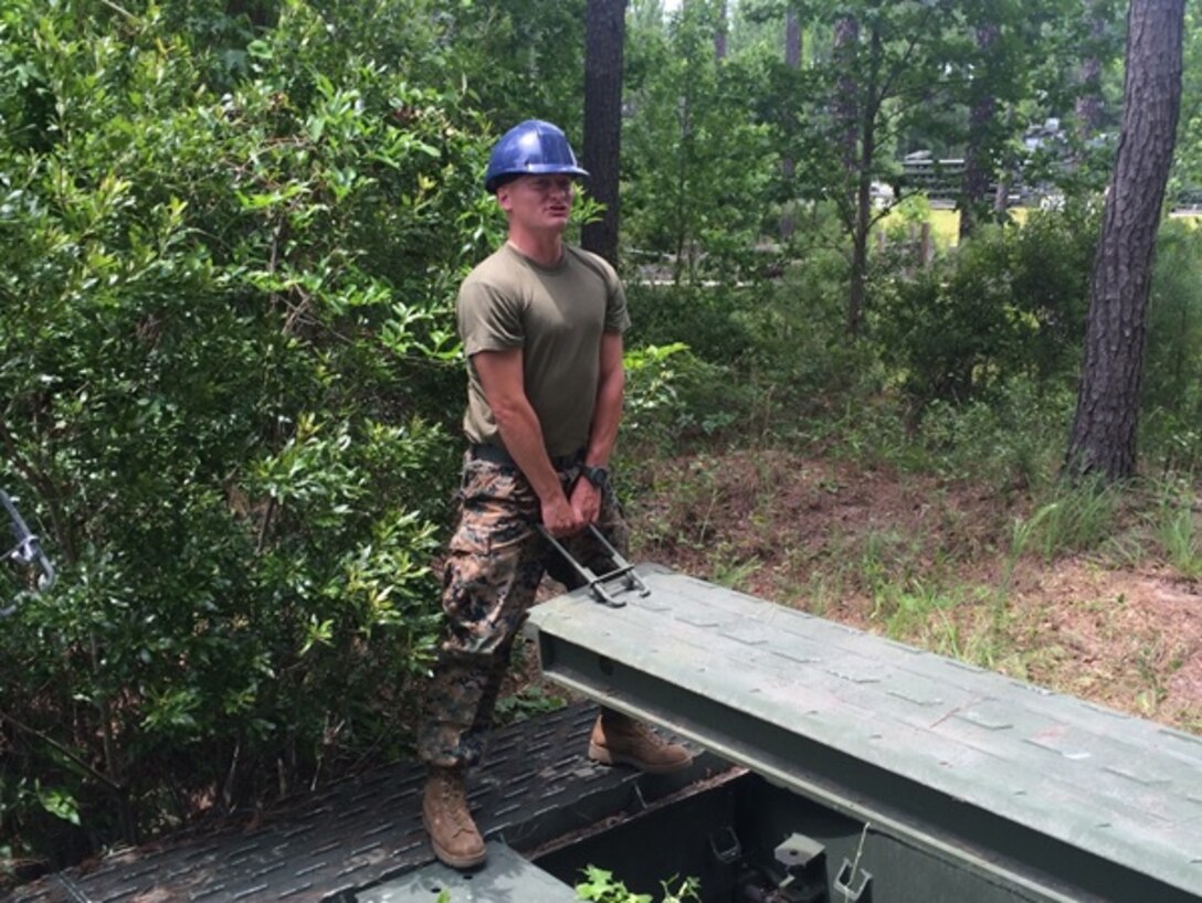 Second Lieutenant Brock Yackey, attached to Combat Engineer Officer course 5-16 lifts a component of a bridge, June 22, 2016 . CEO students are given class on the design, construction and employment of these bridges.
