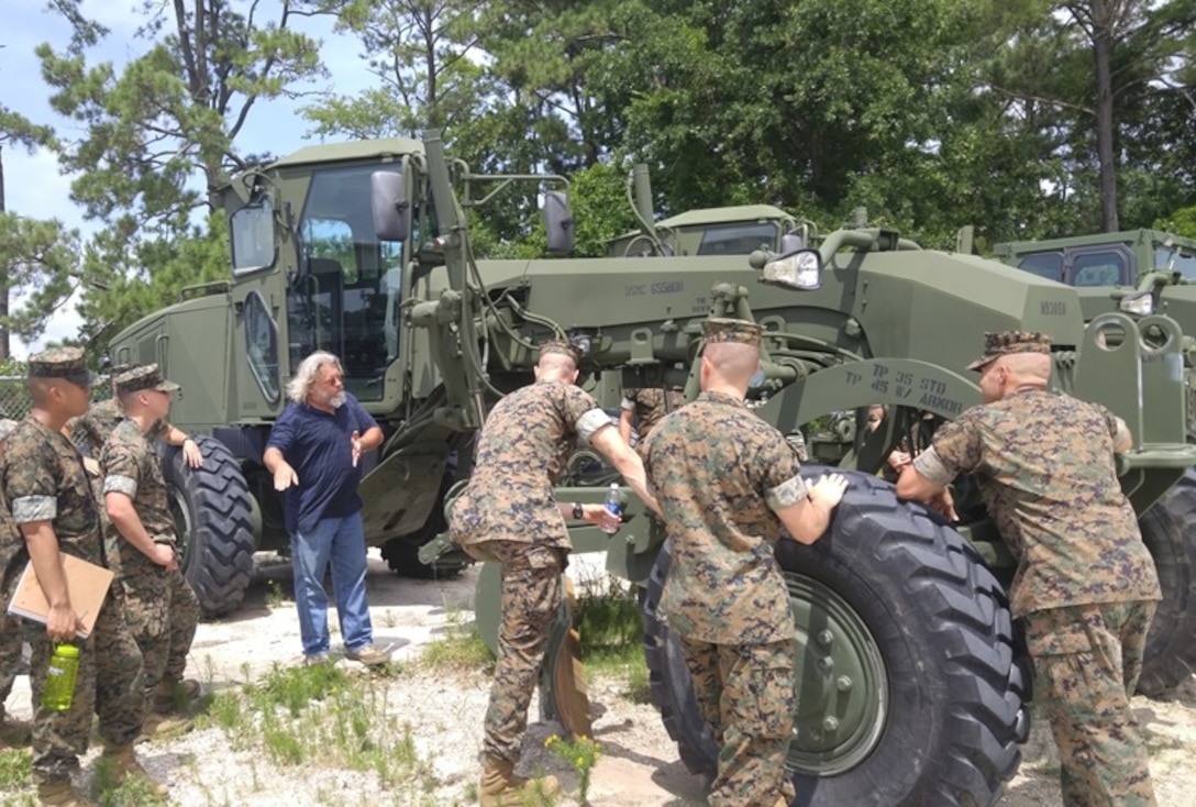 Mr. Franklin Miller, center, an instructor with Combat Engineer Instruction Company, teaches the students of Combat Engineer Officer course 7-16 (CEO 7-16) about the capabilities of the 120M Road Grader, July 11, 2016. The 120M Road Grader is a machine used primarily for general construction and maintenance of roads and aircraft runways. Pictured from left to right are Second Lieutenants Philip Coralde, Cory Deaton, Mr. Franklin Miller, Second Lieutenants Jacob Cybulski, Kevin Roy, and Gunnery Sergeant William Satterfield.
