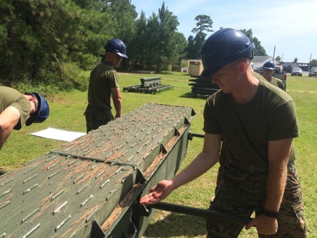Marines attached to Combat Engineer Officer course 5-16 (CEO 5-16) build a medium girder bridge as part of their required training before entering the fleet, June 22, 2016 . Pictured from left to right are Second Lieutenants Justin Wilkison, Patrick Cagas, and Nicholas Downey.  
