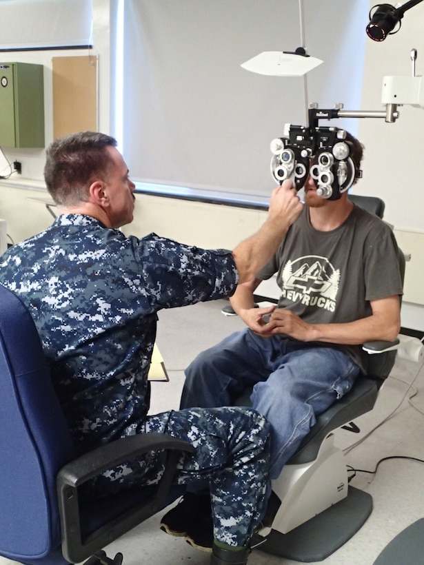 Capt. Philbrook Mason, an optometrist from the Navy Operational Support Center, Quincy, Mass., conducts an eye exam on a patient during Greater Chenango Cares on July 15, 2016.  Greater Chenango Cares is one of the Innovative Readiness Training missions which provides real-world training in a joint civil-military environment while delivering world class medical care to the people of Chenango County, N.Y., from July 15-24.
