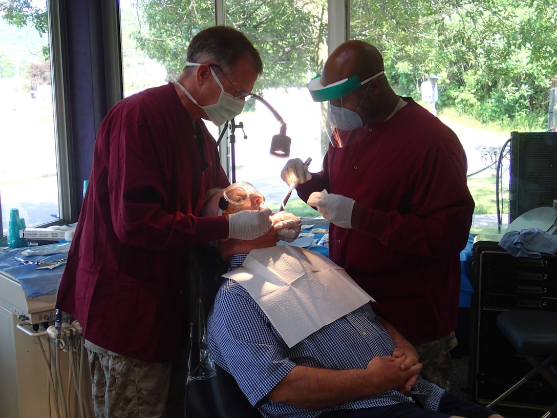 Lt. Blair Wilcox, a Navy dentist from the 4th Dental Battalion, Fort Worth, TX and Sgt. Jerome Capers, a dental technician from Company A, 48th Combat Support Hospital, Fort Story, Va., provide dental care during Greater Chenango Cares on July 15, 2016.  Greater Chenango Cares is one of the Innovative Readiness Training events which provides real-world training in a joint civil-military environment while delivering world class medical care to the people of Chenango County, N.Y., from July 15-24.