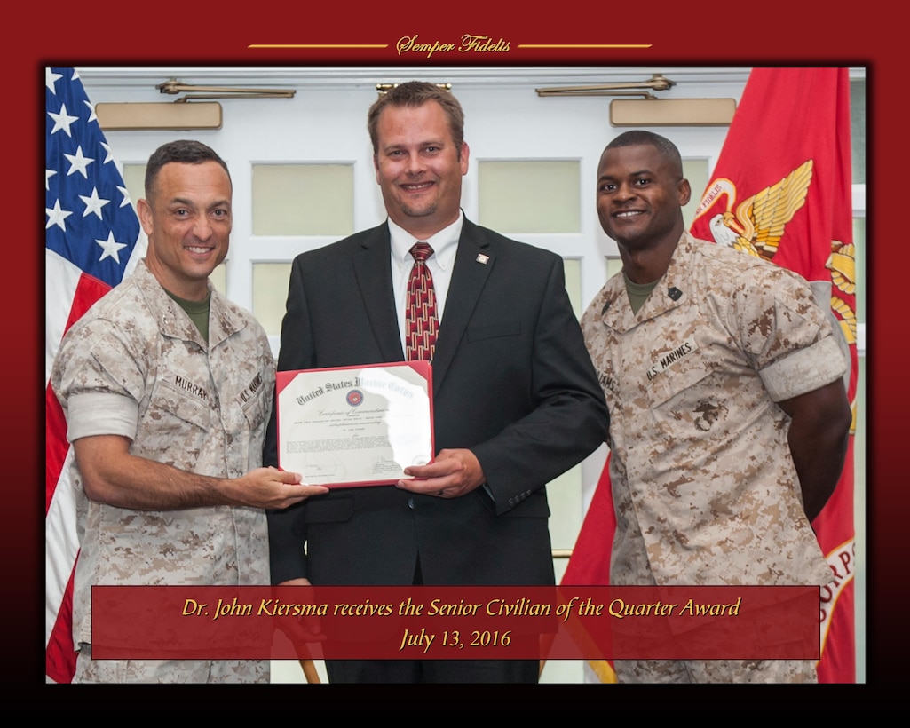 Col. Joseph Murray, commander of Marine Corps Installations National Capital Region - Marine Corps Base Quantico, and command Sgt. Maj. Charles Williams stand with John Kiersma, deputy director of the Business Performance Office, who received the Senior Civilian of the Quarter award for the second quarter of 2016 on July 13.