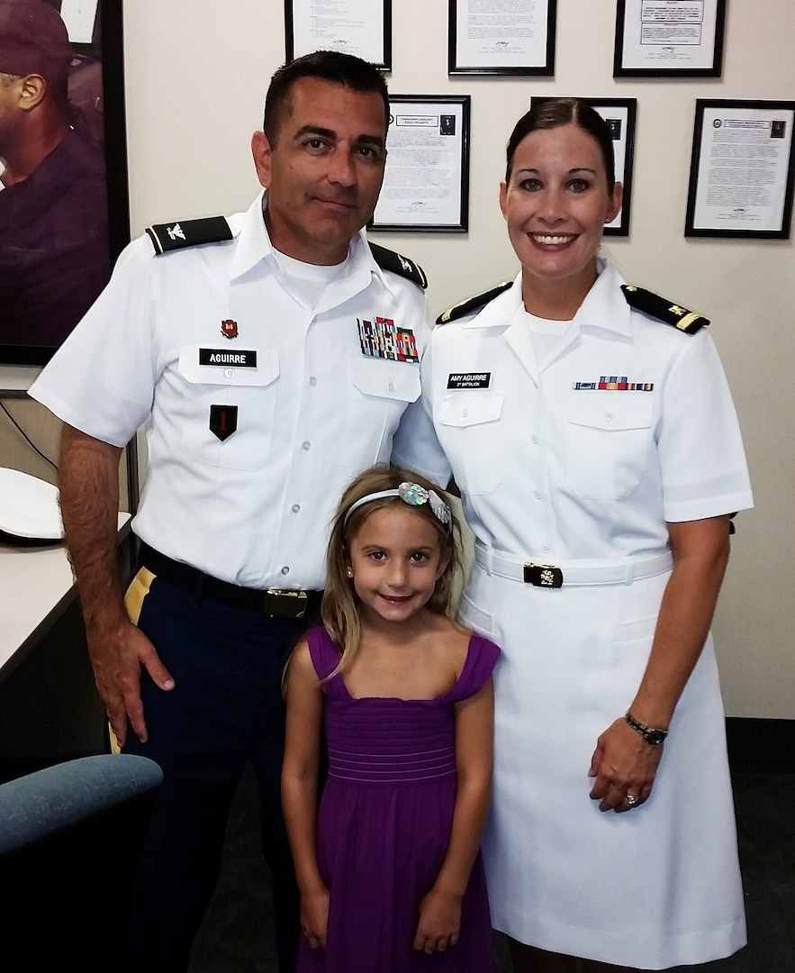 Navy Lt. j.g. Amy Aguirre (right, pictured as an Ensign) poses with her husband, Mario, and daughter, Isabella, after graduating from the Navy Reserve Basic Qualification Course for Supply Corps officers in 2014. Her husband retired as a colonel from the Army Reserves in
January.