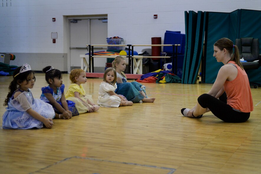 Children from the Youth Center at Minot Air Force Base, N.D., stretch before Princess Dance Camp, June 29, 2016. This camp was part of the summer programs offered by the youth center. (U.S. Air Force photo/Airman 1st Class Jessica Weissman)  