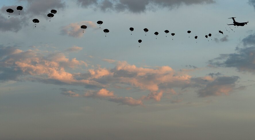 Members of the 82nd Airborne Division jump from a C-17 Globemaster III during a mass tactical parachute jump onto Sicily Drop Zone at Fort Bragg, N.C., July 12, 2016. During the battalion mass tactical week, Army and Air Force units worked together to improve interoperability for worldwide crisis, contingency and humanitarian operations. (U.S. Air Force photo/Senior Airman Ericka Engblom)