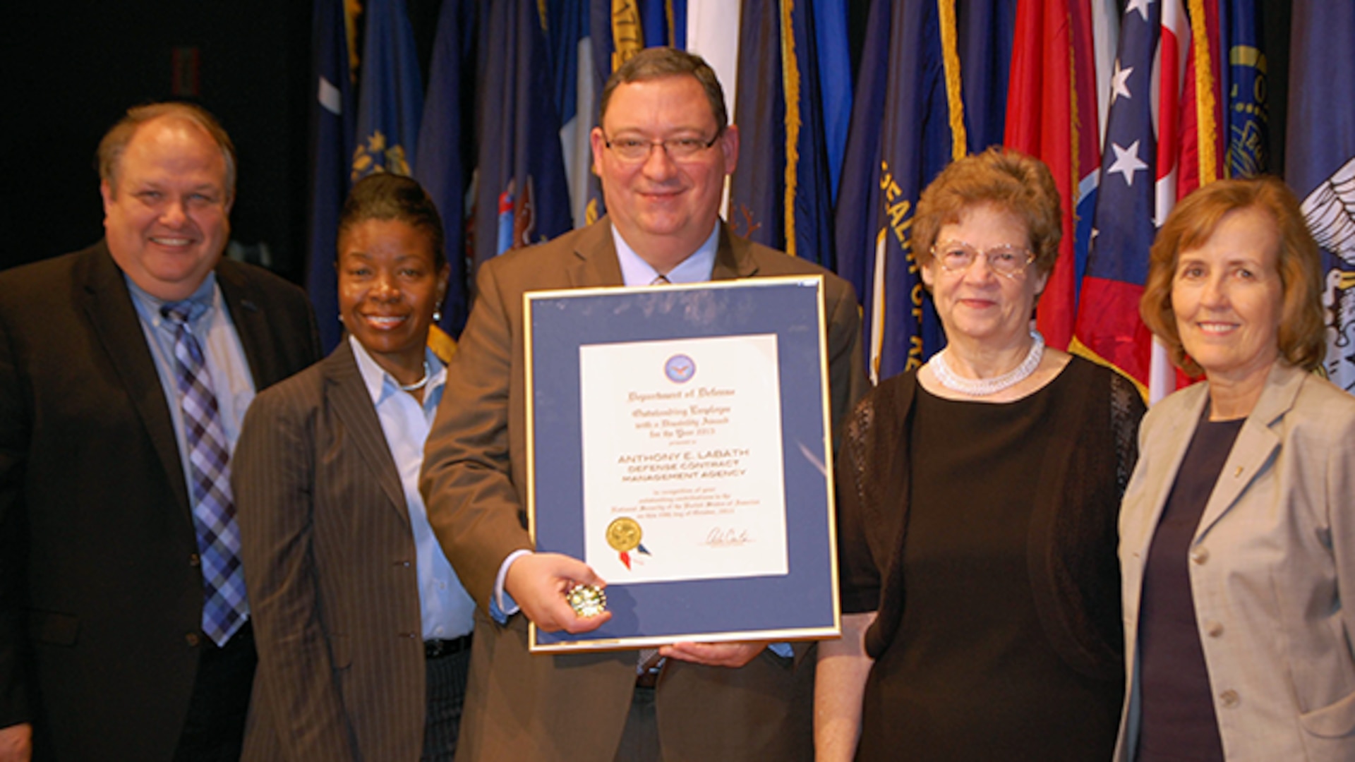 Anthony Labath, Defense Contract Management Agency Engineering and Analysis general engineer, stands with his wife Judith (second from right) and agency leadership representatives James Russell, deputy director; Linda Galimore, Equal Employment Opportunity director; and Karron Small, E&A executive director, at the 2015 Secretary of Defense Award to Outstanding Civilian and Service Members with Disabilities ceremony Nov. 3 at the Pentagon. Labath was one of 19 recipients of the award presented to those who epitomize the qualities and core values of the Department of Defense, are committed to excellence, and contribute significantly to the ability to keep the nation safe and secure. 