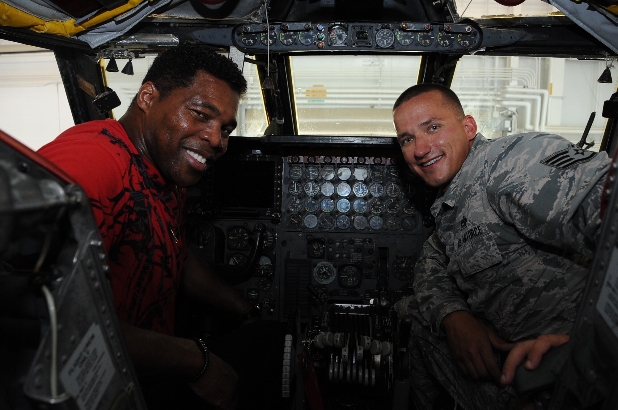 Herschel Walker, a former NFL running back, and Staff Sgt. Matthew Lokitis, 96 Aircraft Maintenance Unit crew chief, sit on the flight deck of a B-52 Stratofortress at Barksdale Air Force Base, La., July 12, 2016. While on base, Walker received an up close look at the long-range bomber and learned about its devastating combat capabilities. (U.S. Air Force photo/Airman 1st Class Stuart Bright)