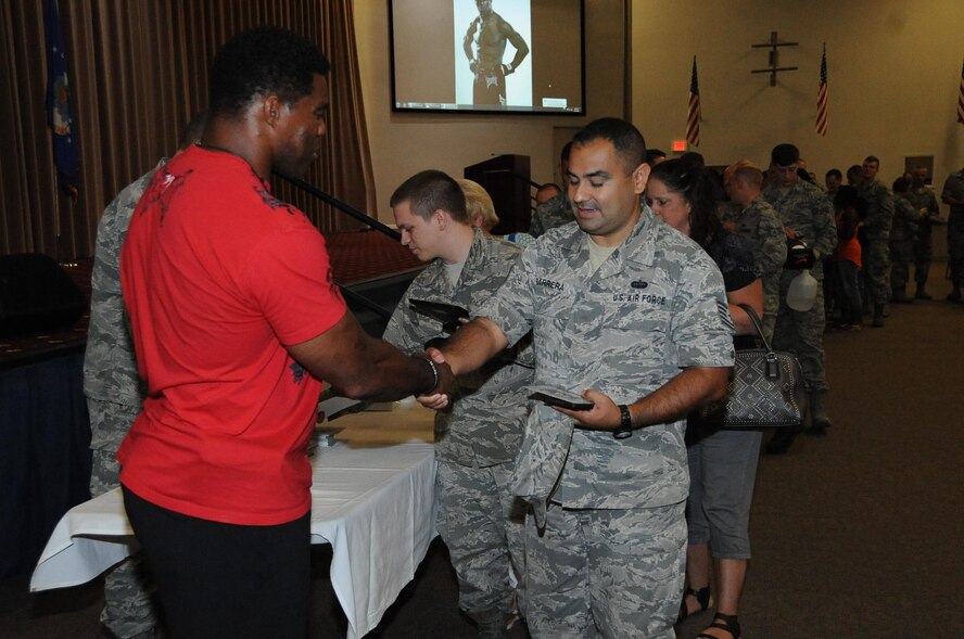 Airmen line up to meet Herschel Walker after he spoke to them about his battle with Dissociative Identity Disorder at Barksdale Air Force Base, La., July 12, 2016. Airmen brought footballs and other memorabilia for Walker, former NFL running back, to sign. (U.S. Air Force photo/Airman 1st Class Stuart Bright)