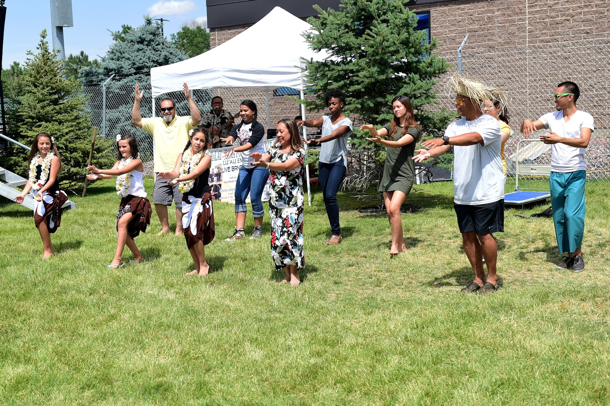 Magic of the Pacific Islands Polynesian dancers teach Team Buckley members an authentic Polynesian dance July 15, 2016, during Diversity Day on Buckley Air Force Base, Colo. Diversity Day provided an opportunity to explore and celebrate the accomplishments and cultures of a diverse military force, which included food, dancing and music from various cultures. (U.S. Air Force photo by Airman 1st Class Gabrielle Spradling/Released)