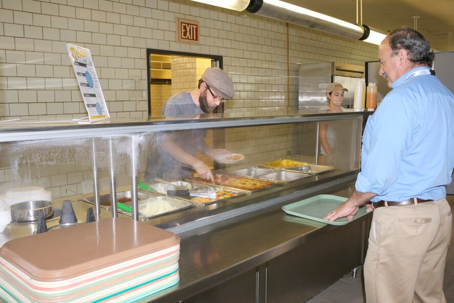 Stefan Fudge, left, and Anna Ballard, second from left, serve a customer at the Café 100 new Hot Line. The new line offers prepared entrées, which provides faster service to accommodate AEDC team members’ lunch breaks. (U.S. Air Force photo/Holly Peterson)