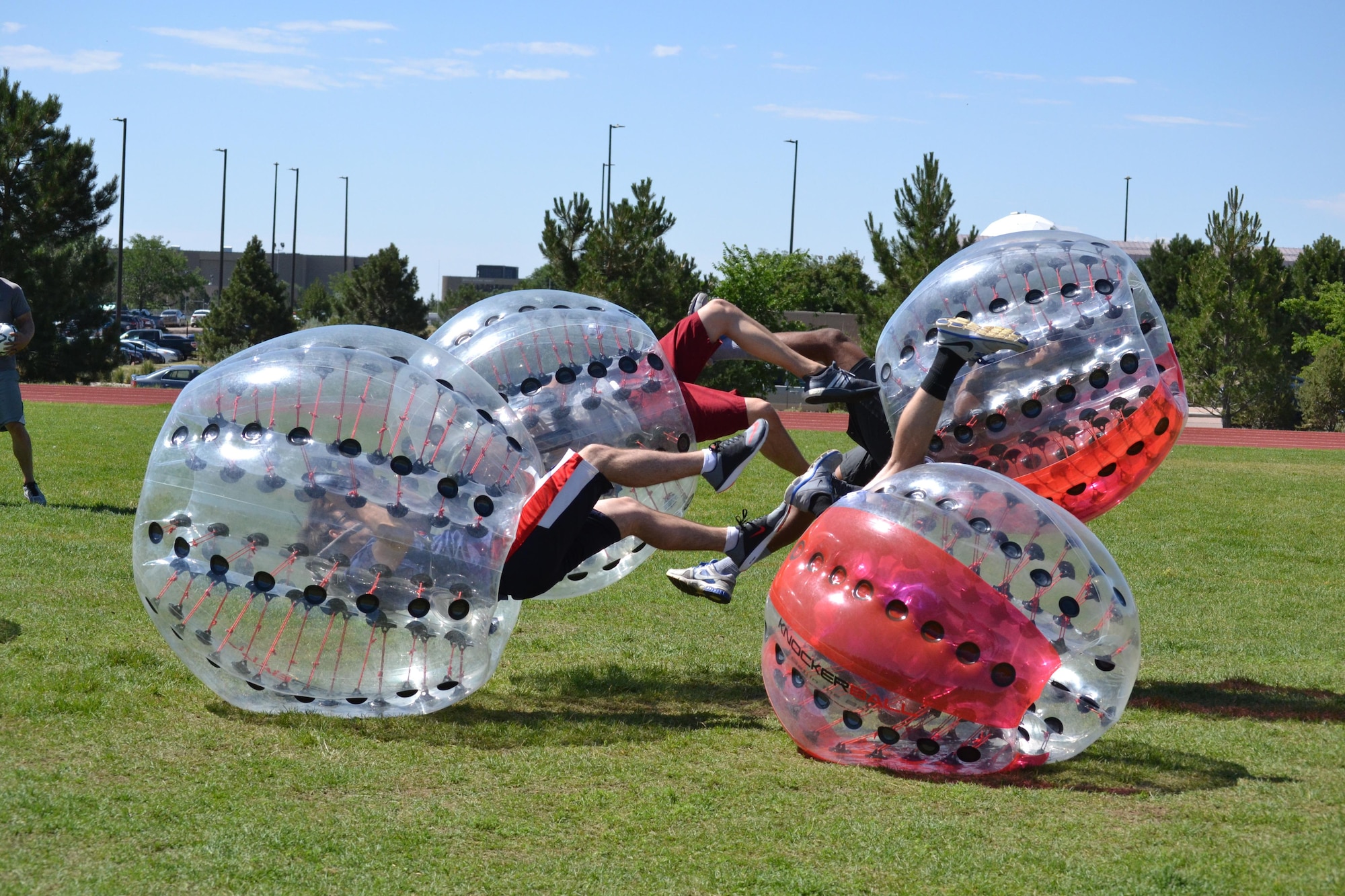Knockerball players send each other flying during the Summer Slam Base Picnic at Schriever Air Force Base, Colorado, Friday, July 15, 2016. Knockerball is a soccer game that consists of two five-person teams inside large inflatable spheres that protect players from heavy impacts while playing. (U.S. Air Force photo/Brian Hagberg)