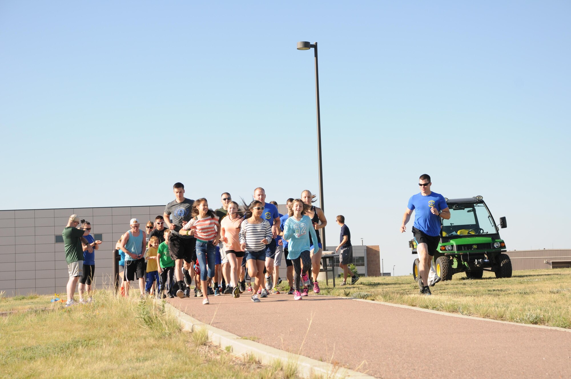 Schriever Airmen and families begin a fun run during the Summer Slam Base Picnic at Schriever Air Force Base, Colorado, Friday, July 15, 2016. The run kicked off the day’s festivities. (U.S. Air Force photo/Airman William Tracy)