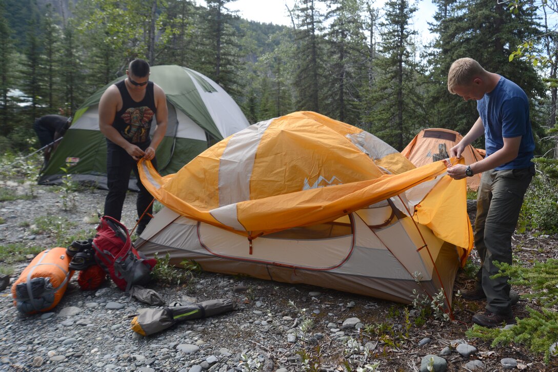 Campers place a rain cover over their tent during a chaplain-sponsored camping trip near Lion’s Head, Alaska, July 9, 2016. The Joint Base Elmendorf-Richardson chaplain community hosted the whitewater rafting and camping trip for single services members and other Department of Defense partners. (U.S. Air Force photo by Airman 1st Class Christopher R. Morales)