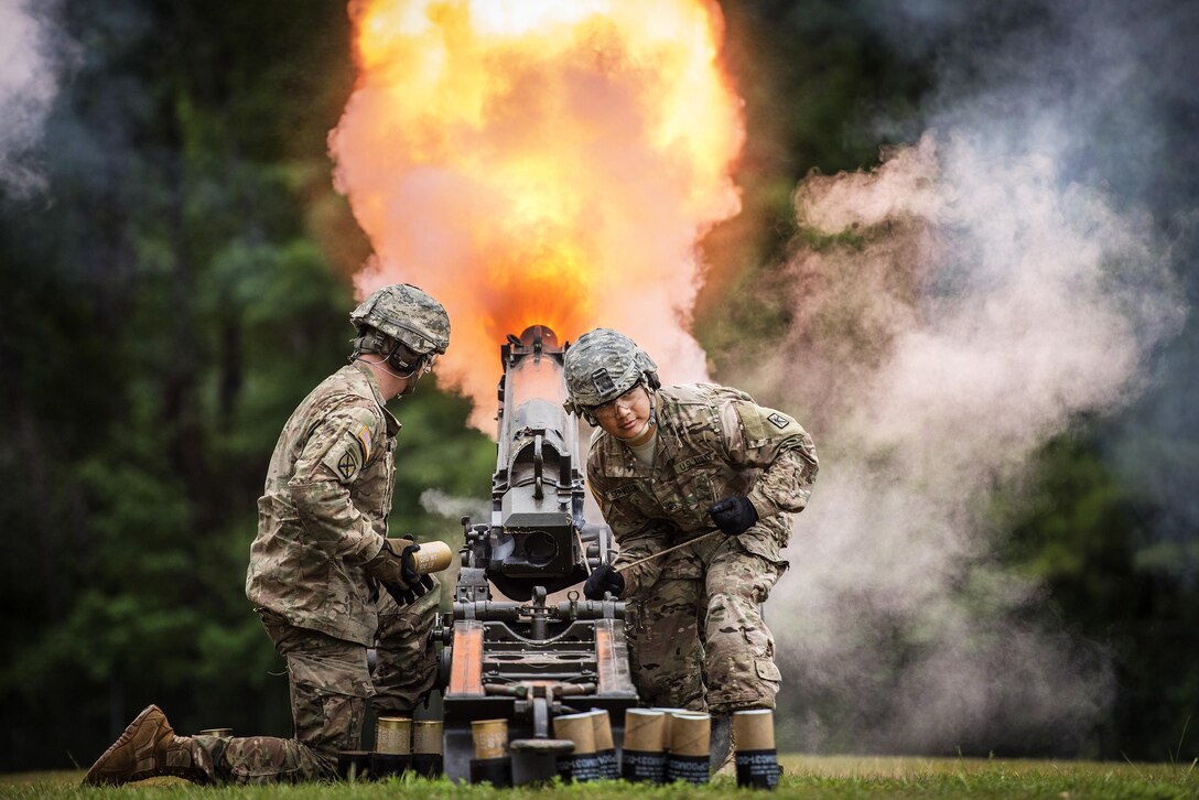 Army Sgt. Ryan Skelton, left, and Staff Sgt. Elvis Servellon fire an M116 howitzer during a retirement ceremony for Army Brig. Gen. Janice M. Haigler, deputy commander of the 335th Signal Command Theater, at Fort Jackson, S.C., July 16, 2016. Army photo by Staff Sgt. Ken Scar