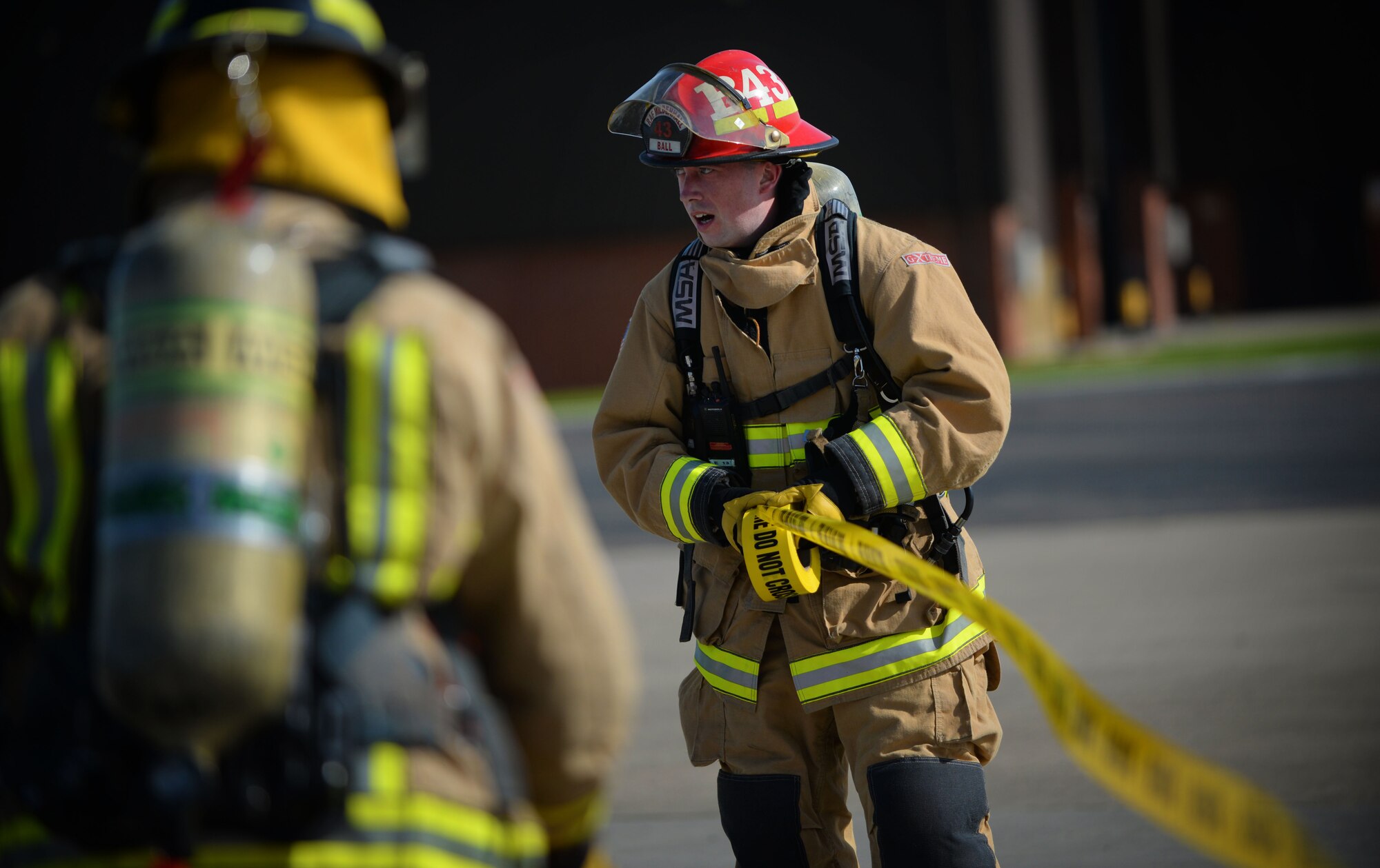 U.S. Air Force Tech. Sgt. Jeffrey Ball, 100th Civil Engineer Squadron firefighter, cordons off an area during an exercise July 15, 2016, on RAF Mildenhall, England. The exercise tested Team Mildenhall first responders during a simulated fuel spill. (U.S. Air Force photo by Senior Airman Christine Halan)