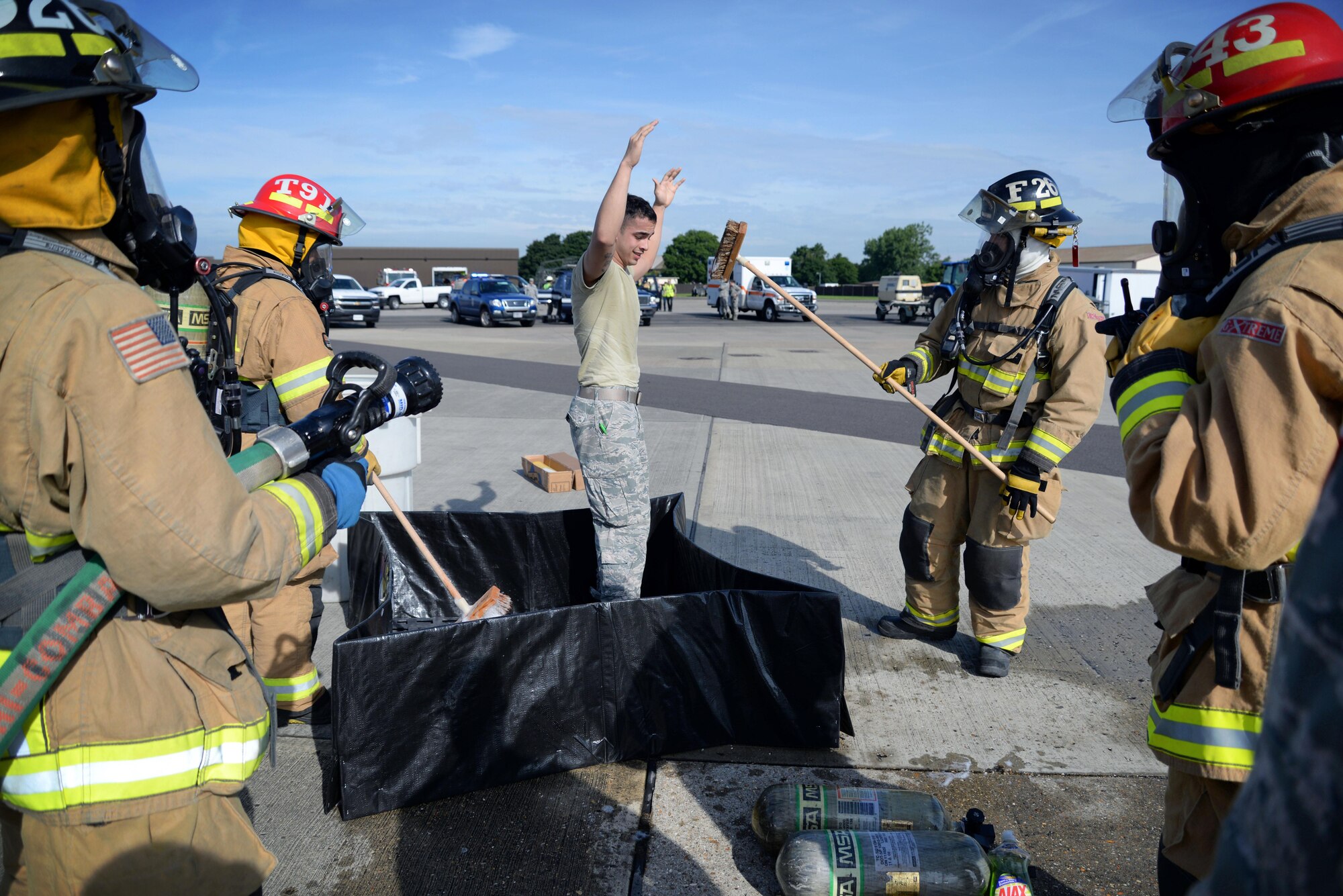 U.S. Air Force Airmen from the 100th Civil Engineer Squadron Fire Department conduct a simulated decontamination during an exercise July 15, 2016, on RAF Mildenhall, England. The exercise tested Team Mildenhall first responders during a simulated fuel spill.  (U.S. Air Force photo by Senior Airman Christine Halan)