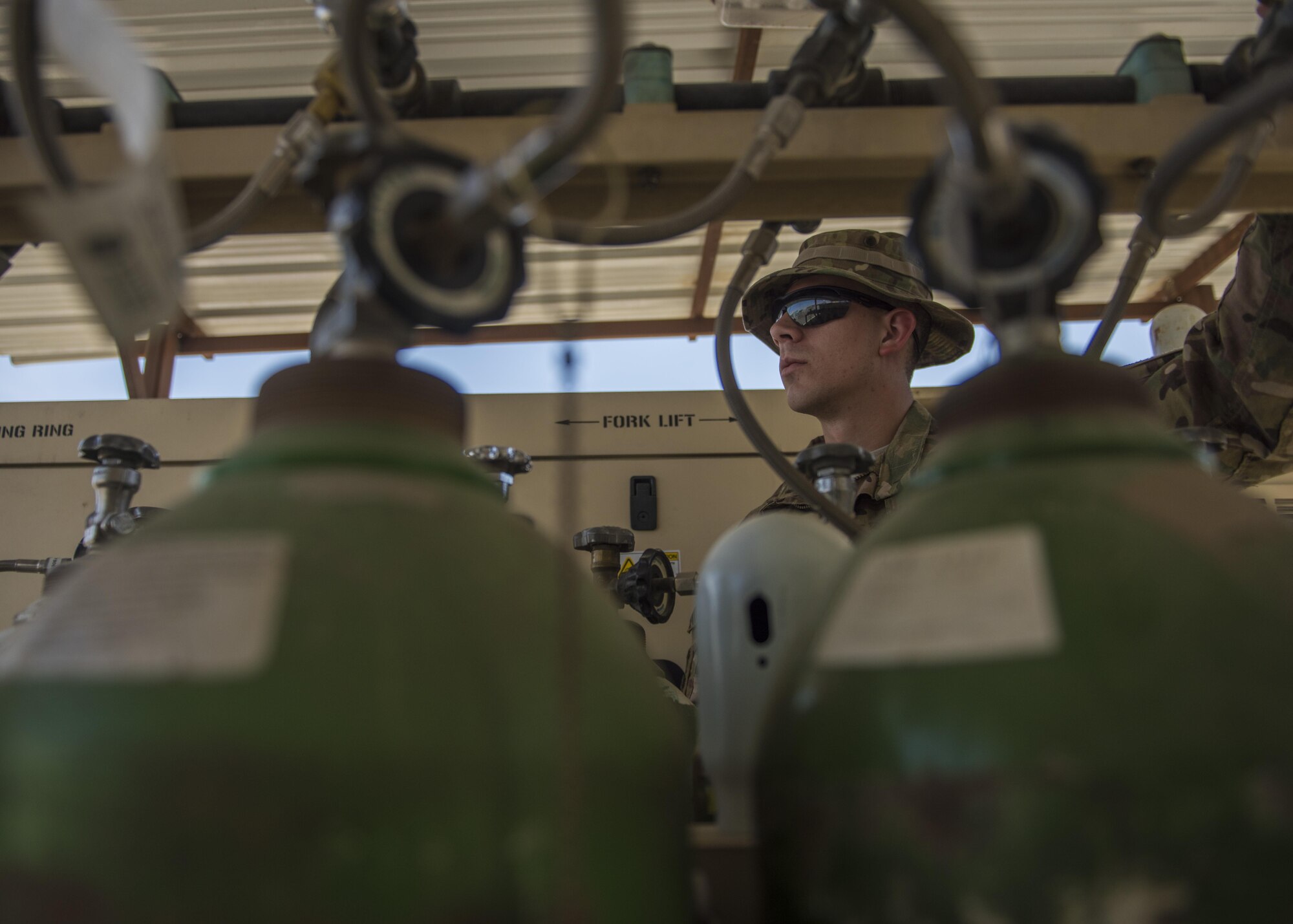 Staff Sgt. James Hughes, 455th Expeditionary Medical Group, biomedical equipment technician, turns the knob on an oxygen tank, Bagram Airfield, Afghanistan, July 18, 2016. Tanks are opened upon delivery, to ensure full potential of medical oxygen is released. (U.S. Air Force photo by Senior Airman Justyn M. Freeman)