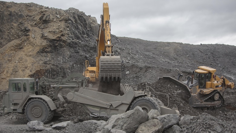 Heavy equipment operators from across Marine Forces Reserve move material to complete a runway extension project at Innovative Readiness Training Old Harbor, Alaska, July 9, 2016. The project would extend the existing Old Harbor runway by 2,000 feet, which would allow larger aircraft to land in Old Harbor. IRT Old Harbor is part of a civil and joint military program to improve military readiness while simultaneously providing quality services to underserved communities throughout the United States.