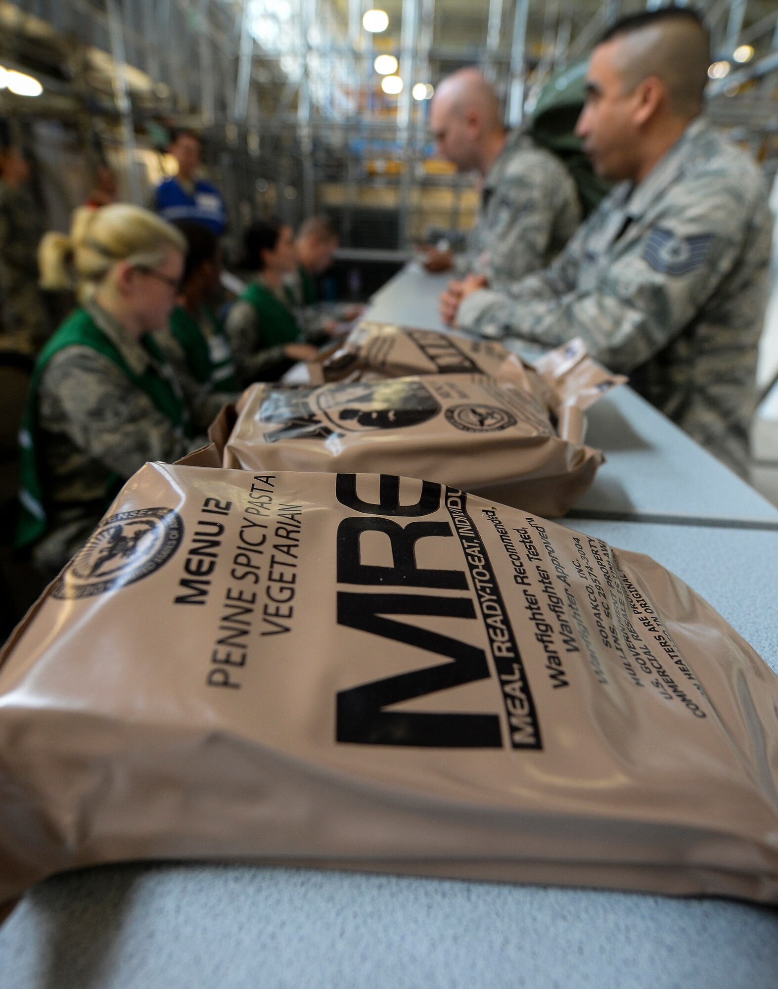 Meals Ready-To-Eat lay on a counter while U.S. Air Force Airmen out process through a personnel deployment function line during an exercise July 14, 2016, on RAF Mildenhall, England. The exercise involved a four-part process in which participants were issued bags and equipment from the mobility section, processed through the PDF line, received briefings and then finally boarded and departed the base in a KC-135 Stratotanker. The exercise was conducted to test the base’s ability to quickly respond to threats and assist NATO allies. (U.S. Air Force photo by Staff Sgt. Micaiah Anthony)