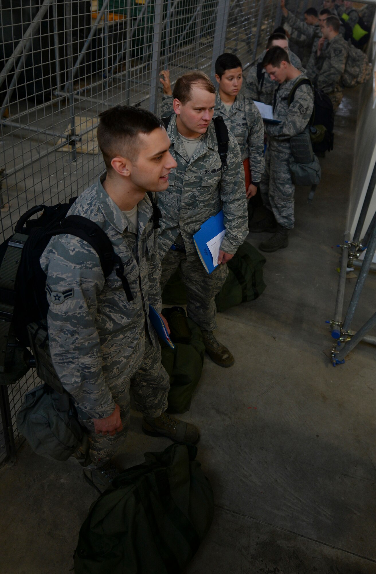 U.S. Air Force Airmen wait in a personnel deployment function line during an exercise July 14, 2016, on RAF Mildenhall, England. The exercise involved a four-part process in which participants were issued bags and equipment from the mobility section, processed through the PDF line, received briefings and then finally boarded and departed the base in a KC-135 Stratotanker. The exercise was conducted to test the base’s ability to quickly respond to threats and assist NATO allies. (U.S. Air Force photo by Staff Sgt. Micaiah Anthony)