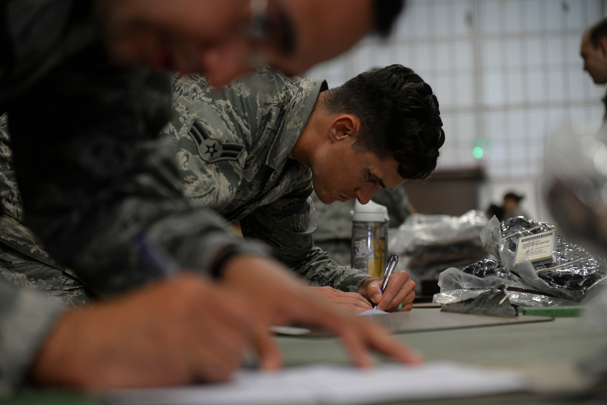 U.S. Air Force Airman 1st Class Luke Sarafian, 100th Civil Engineer Squadron Emergency Management apprentice, fills out paperwork in the 100th Logistics Readiness Squadron mobility section during an exercise July 14, 2016, on RAF Mildenhall, England. Airmen from various units were selected for the exercise to test and hone the base’s ability to equip, out-process, brief, load and deploy personnel.  (U.S. Air Force photo by Staff Sgt. Micaiah Anthony)