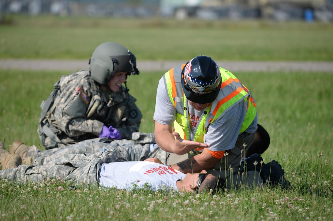 Nebraska Army National Guard Sgt. Samantha Herschenbach, left, and Team Rubicon safety officer with Nebraska Army National Guard Timothy “Guns” Waynick treat simulated patients during Exercise Patriot North 2016 at Volk Field Air National Guard Base, Wis., July 18, 2016. Air National Guard photo by Senior Master Sgt. David H. Lipp