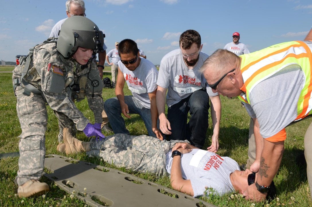 Nebraska Army National Guard Sgt. Samantha Herschenbach, left, and Team Rubicon safety officer Timothy “Guns” Waynick, right, treats a patient during Exercise Patriot North 2016 at Volk Field Air National Guard Base, Wis., July 18, 2016. Air National Guard photo by Senior Master Sgt. David H. Lipp