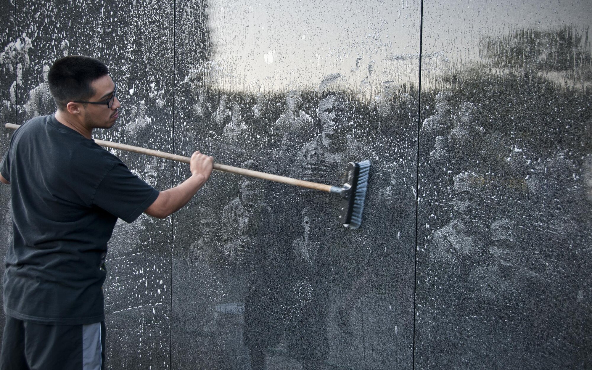 Staff Sgt. José Nunez, 459th Maintenance Squadron crew chief, washes the Korean War Veterans Memorial wall in Washington D.C., July 17, 2016. Members of the 459th Air Refueling Wing and their families volunteered to clean the memorial prior to its opening to the public for the day. (U.S. Air Force photo/Staff Sgt. Kat Justen)