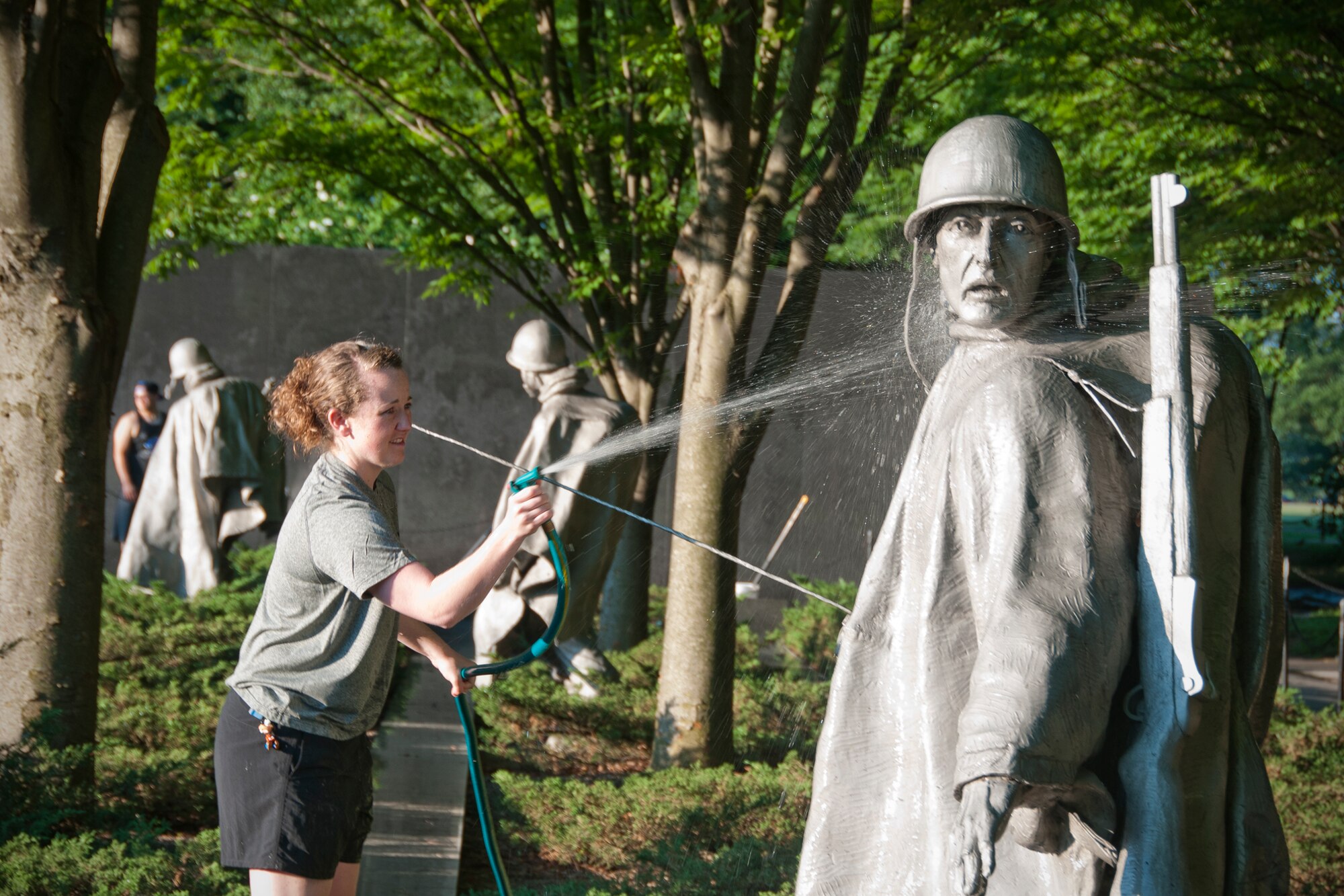 Senior Airman Katie Bobbitt, 459th Maintenance Squadron crew chief, uses a hose to wash a statue at the Korean War Veterans Memorial in Washington D.C., July 17, 2016. Members of the 459th Air Refueling Wing and their families volunteered to clean the memorial prior to its opening to the public for the day. (U.S. Air Force photo/Staff Sgt. Kat Justen)