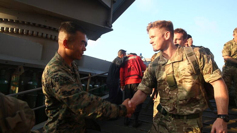 Maj. Darryl Lamberth, commander of Marine troops for the amphibious dock landing ship USS Whidbey Island, greets United Kingdom Royal Marines from 42nd Royal Marine Commando Unit, Juliet Company, as they board the USS Whidbey Island in order to show interoperability between U.S. and United Kingdom military forces, July 7, 2016. 22nd MEU, deployed with the Wasp Amphibious Ready Group, is conducting naval operations in the U.S. 6th Fleet area of operations in support of U.S. national security interests in Europe. 