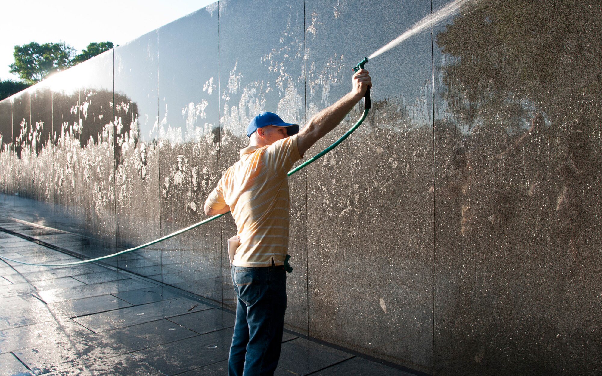 A first sergeant with the 459th Air Refueling Wing hoses soap off the Korean War Veterans Memorial wall in Washington D.C., July 17, 2016. Volunteers from the 459th ARW came out in the early morning hours to clean the memorial prior to the arrival of daily visitors. (U.S. Air Force photo/Staff Sgt. Kat Justen) 