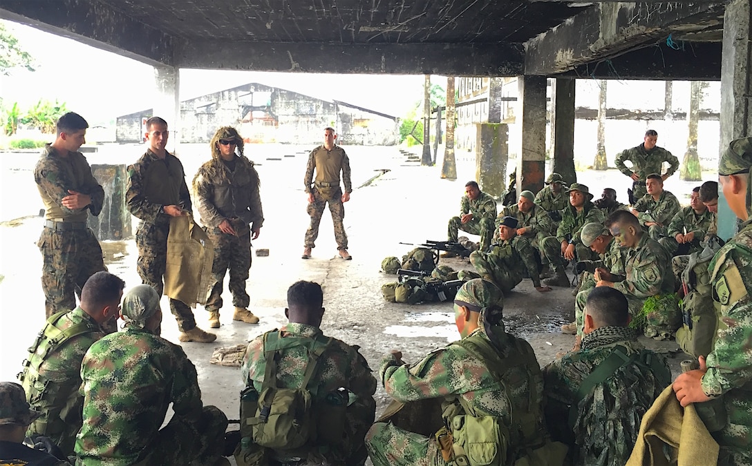 TUMACO, Colombia - Gunnery Sgt. Randy Wilson (far right),  a platoon sergeant with 4th Force Reconnaissance Company, 4th Marine Division, Marine Forces Reserve, provides input as Colombian Marines conduct mission planning for the final training event in Tumaco, Colombia, June 8, 2016. Marines from 4th Force Reconnaissance Co. participated in a two-week mobile training team deployment to exchange skills with new Colombian Reconnaissance Marines May 29 – June 12. Augmenting the active component to fill a needed role in an ongoing mission with a partner nation is one of the ways Marine Forces Reserve remains ready to respond to any contingency the nation might face. (Photo courtesy of 4th Force Reconnaissance Company)