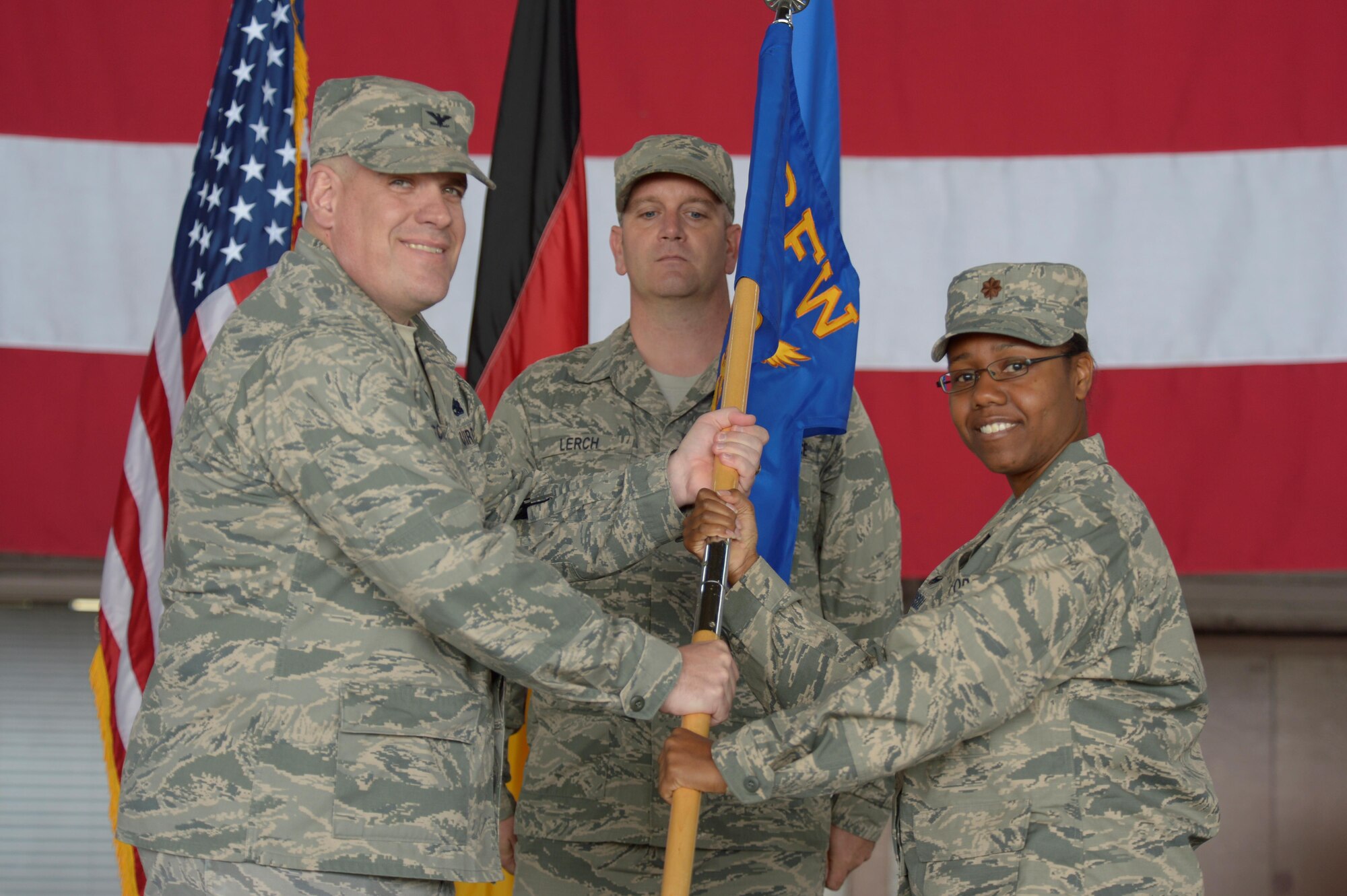 U.S. Air Force Col. Stephen Scherzer, 52nd Maintenance Group commander, left, hands the 52nd Maintenance Squadron guidon to U.S. Air Force Maj. Strysan Murrell, 52nd MXS commander, speaks during a redesignation ceremony in Hangar One at Spangdahlem Air Base, Germany, July 14, 2016. The 52nd Component Maintenance Squadron and 52nd Equipment Maintenance Squadron have been retired and are now consolidated into the new 52nd Maintenance Squadron. (U.S. Air Force photo by Staff Sgt. Jonathan Snyder/Released)
