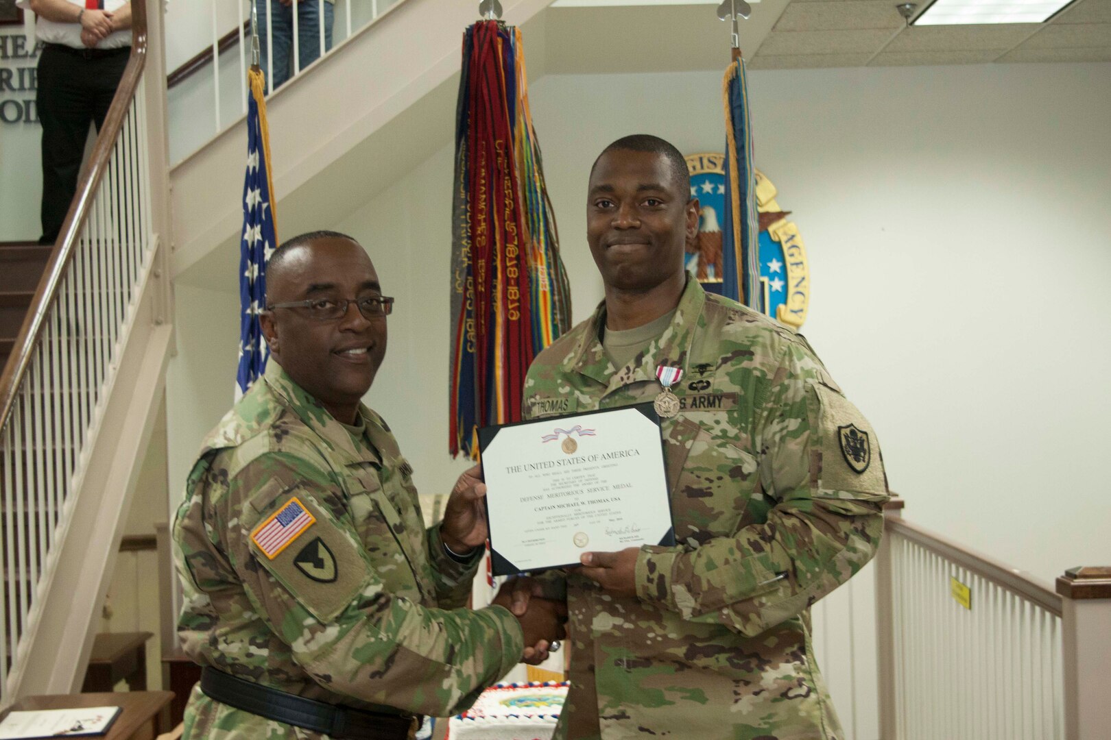 Former DLA Distribution commander Army Brig. Gen. Richard Dix, left, presents the Defense Meritorious Service Medal to Army Capt. Michael Thomas, aide-de-camp.  
