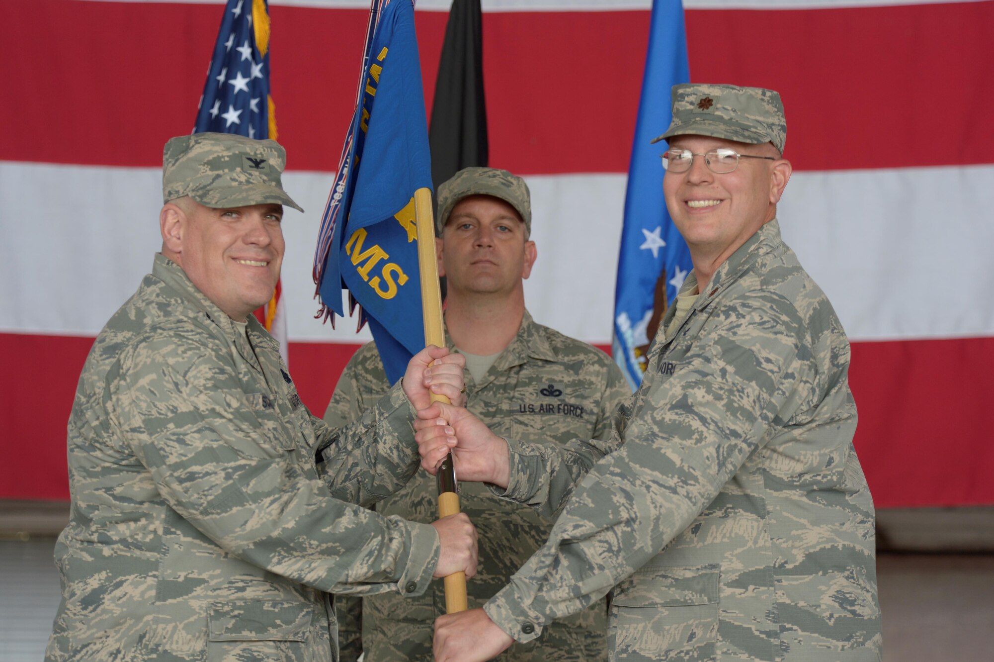 U.S. Air Force Col. Steven Scherzer, 52nd Maintenance Group commander, left, takes the 52nd Equipment Maintenance Squadron guidon from U.S. Air Force Maj. David Marce, 52nd EMS commander, during a redesignation ceremony in Hangar One at Spangdahlem Air Base, Germany, July 14, 2016. The 52nd Component Maintenance Squadron and 52nd Equipment Maintenance Squadron have been retired and are now consolidated into the new 52nd Maintenance Squadron. (U.S. Air Force photo by Staff Sgt. Jonathan Snyder/Released)
