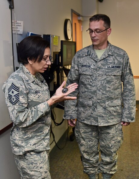 Air Force Reserve Command, Command Chief, Chief Master Sgt. Ericka Kelly looks down at the coin she is about to present to Master Sgt. John Linafelter, 1st Sgt. with 73rd Airlift Squadron for his well executed planning of the Professional Development Seminar held July 7-8, 2016, Scott Air Force Base, Illinois.  The challenge coin has a long military history with an uncertain origin.  To receive a coin is an honor and signifies a token of appreciation. Typically coins are presented as a quick ceremonial handshake. (U.S. Air Force photo/Christopher Parr)