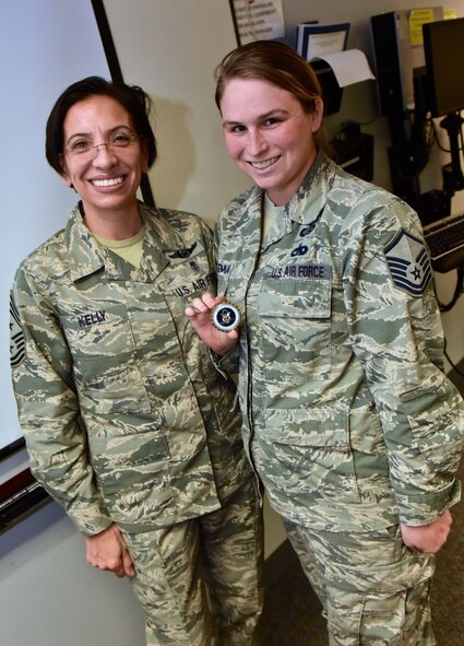 Master Sgt. Beci Hilgeman, chief of education and training at the 932nd Airlift Wing, stands with Air Force Reserve Command, Command Chief, Chief Master Sgt. Ericka Kelly, July 8, 2016, Scott Air Force Base, Illinois.  Kelly presented her Chiefs coin to Hilgeman for demonstrating leadership and helping to organize the Professional Development Seminar that was held just before the July unit training assembly.  (U. S. Air Force photo/Christopher Parr)