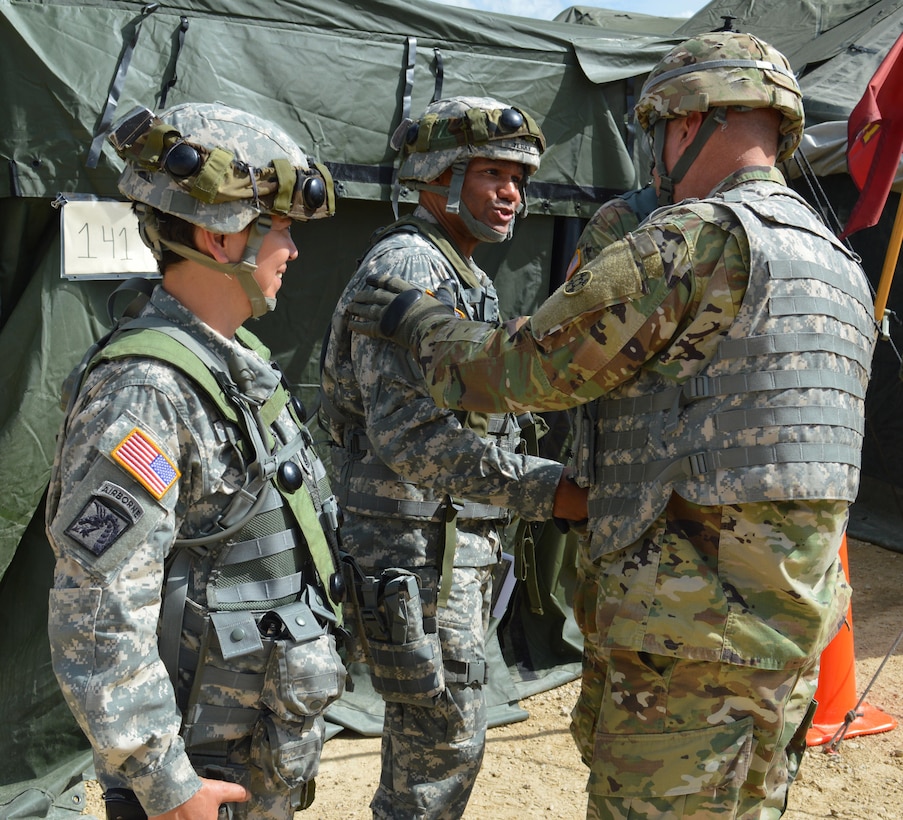 Army Reserve Brig. Gen. Vincent B. Barker (right), commanding general of the 310th Sustainment Command (Expeditionary), shakes hands with Lt. Col. Earl D. Terry, III, battalion commander of the 329th Combat Sustainment Support Battalion (CSSB), headquartered in Parsons, Kansas (center), during Warrior Exercise (WAREX) 86-16-03 at Ft. McCoy, Wis., July 12, 2016.  WAREX is designed to keep Soldiers all across the United States prepare to deploy.