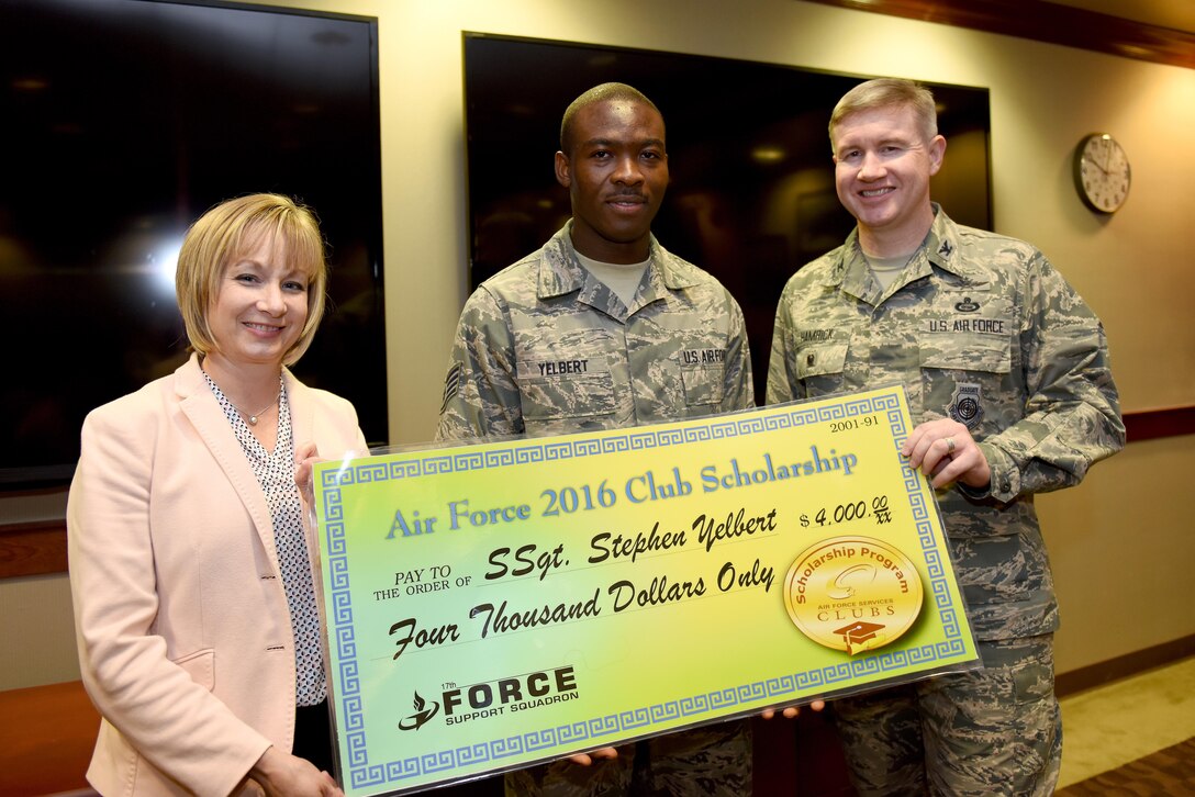 U.S. Air Force Col. Terry Hamrick, 17th Training Wing Vice Commander, and Toni Hansen, 17th Force Support Squadron Director, award Staff Sgt. Stephen Yelbert, , 17th Comptroller Squadron financial services technician and Non-Commissioned Officer in charge for reports and analysis, the Air Force 2016 Club Scholarship for 4,000 dollars at the Norma Brown Building on Goodfellow Air Force Base, Texas, June 28, 2016. Yelbert received 2nd place in the scholarship competition throughout the Air Force. (U.S. Air Force photo by Airman 1st Class Caelynn Ferguson/Released)