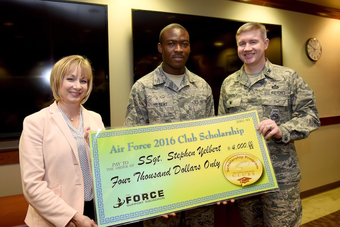 U.S. Air Force Col. Terry Hamrick, 17th Training Wing Vice Commander, and Toni Hansen, 17th Force Support Squadron Director, award Staff Sgt. Stephen Yelbert, , 17th Comptroller Squadron financial services technician and Non-Commissioned Officer in charge for reports and analysis, the Air Force 2016 Club Scholarship for 4,000 dollars at the Norma Brown Building on Goodfellow Air Force Base, Texas, June 28, 2016. Yelbert received 2nd place in the scholarship competition throughout the Air Force. (U.S. Air Force photo by Airman 1st Class Caelynn Ferguson/Released)