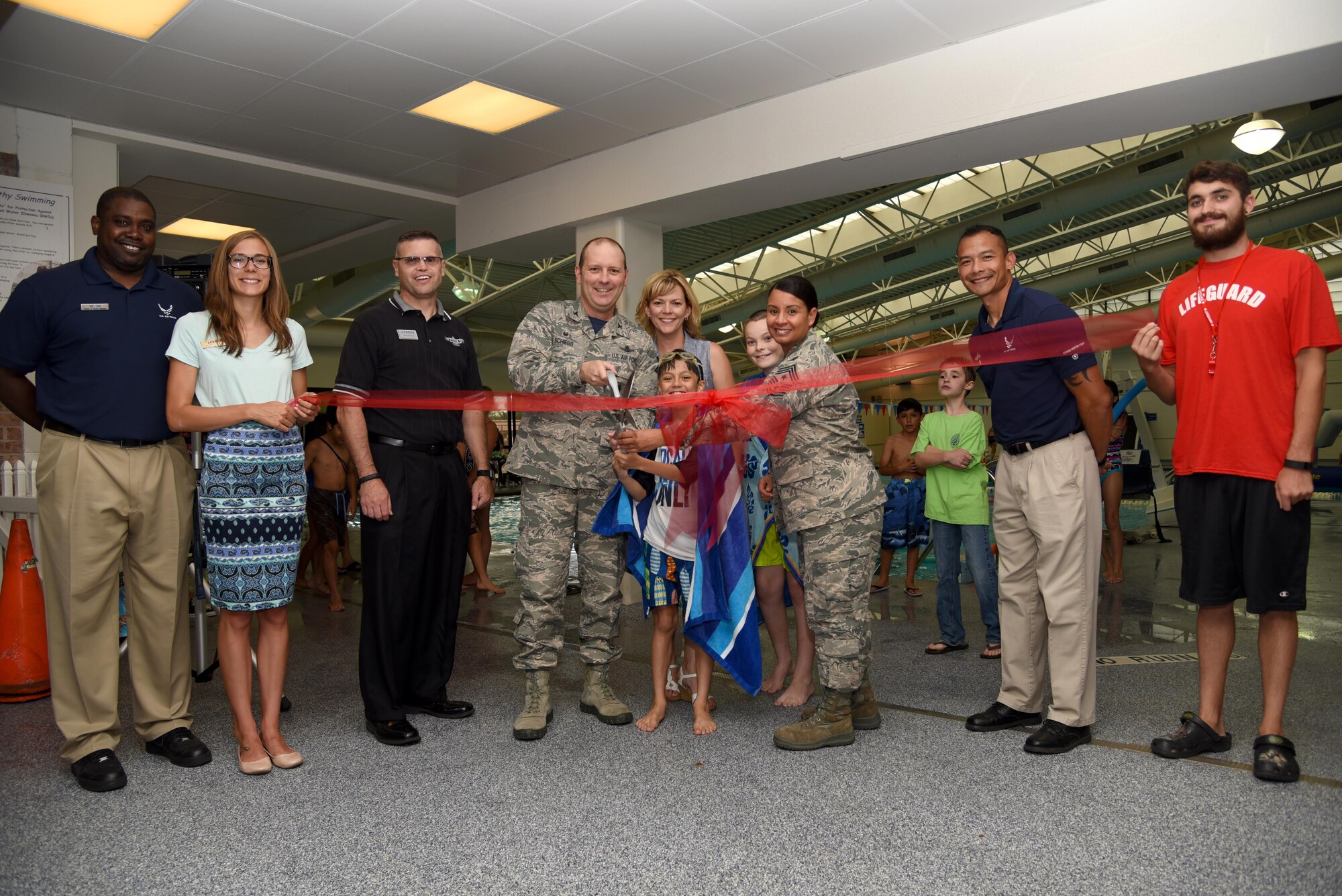 PETERSON AIR FORCE BASE, Colo. – Col. Doug Schiess, 21st Space Wing commander, and Chief Master Sgt. Idalia Peele, 21st Space Wing command chief, cut the ceremonial ribbon at the Peterson Aquatics Center’s Grand Re-Opening at Peterson Air Force Base, Colo., July 15, 2016. The Aquatics Center celebrated the opening with events such as stand-up paddleboard races and an inflatable obstacle course race. (U.S. Air Force photo by Airman 1st Class Dennis Hoffman)