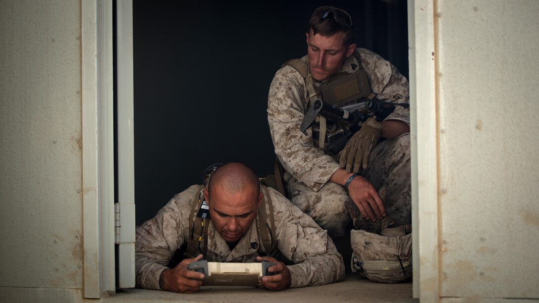 Staff Sgt. Dustin Decou and Sgt. Kevin Peach with 3rd Battalion, 5th Marine Regiment look for nearby threats through the camera of a “dragon fire” at Marine Corps Base Camp Pendleton, California, July 13, 2016. The system, meant to increase initial visibility of the enemy before the Marines need to engage them, was built by the Marine Corps Warfighting Laboratory. It can be tossed and kicked around, is invertible with front and rear cameras, and is both day and night capable. The lab is conducting a Marine Air-Ground Task Force Integrated Experiment in conjunction with Rim of the Pacific exercise to explore new gear and assess its capabilities for potential future use. The Warfighting Lab identifies possible challenges of the future, develops new warfighting concepts, and tests new ideas to help develop equipment that meets the challenges of the future operating environment.