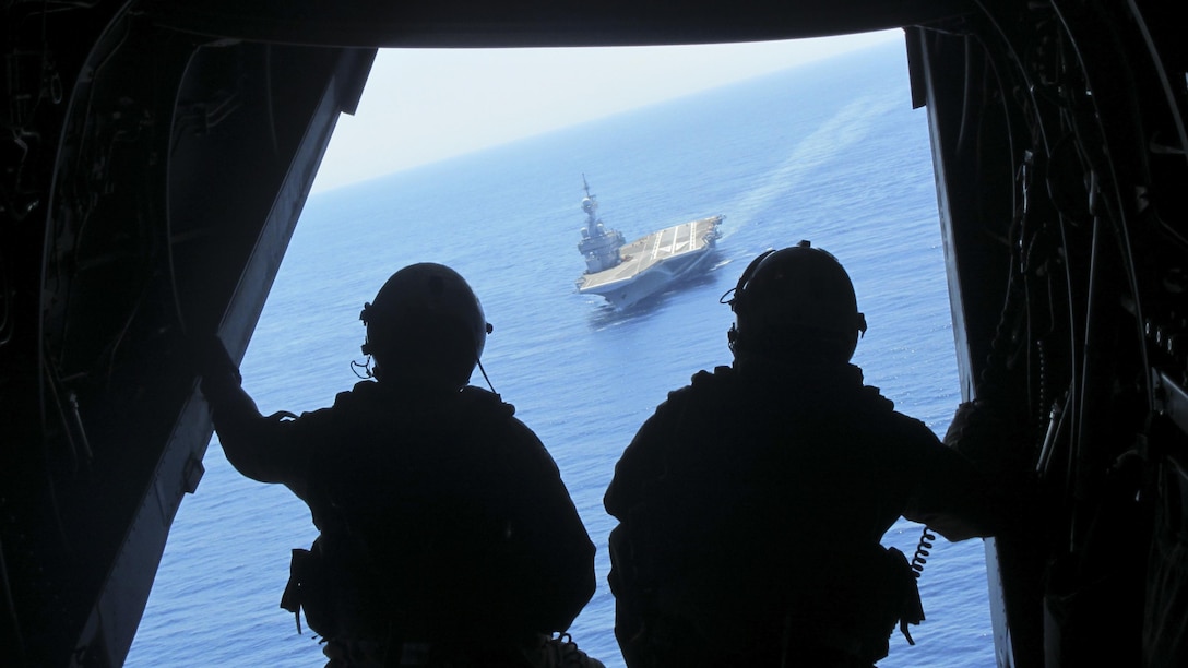 U.S. Marines with Marine Medium Tiltrotor Squadron 263, Special Purpose Marine Air-Ground Task Force-Crisis Response-Africa observe out the back of an MV-22B Osprey as it takes off from the flight deck of the French aircraft carrier Charles de Gaulle, in the Mediterranean Sea, July 6, 2016. Training with the host nation partners allows the U.S. Marines to maintain proficiency in their core skills while also developing the interoperability skills essential for future operations.